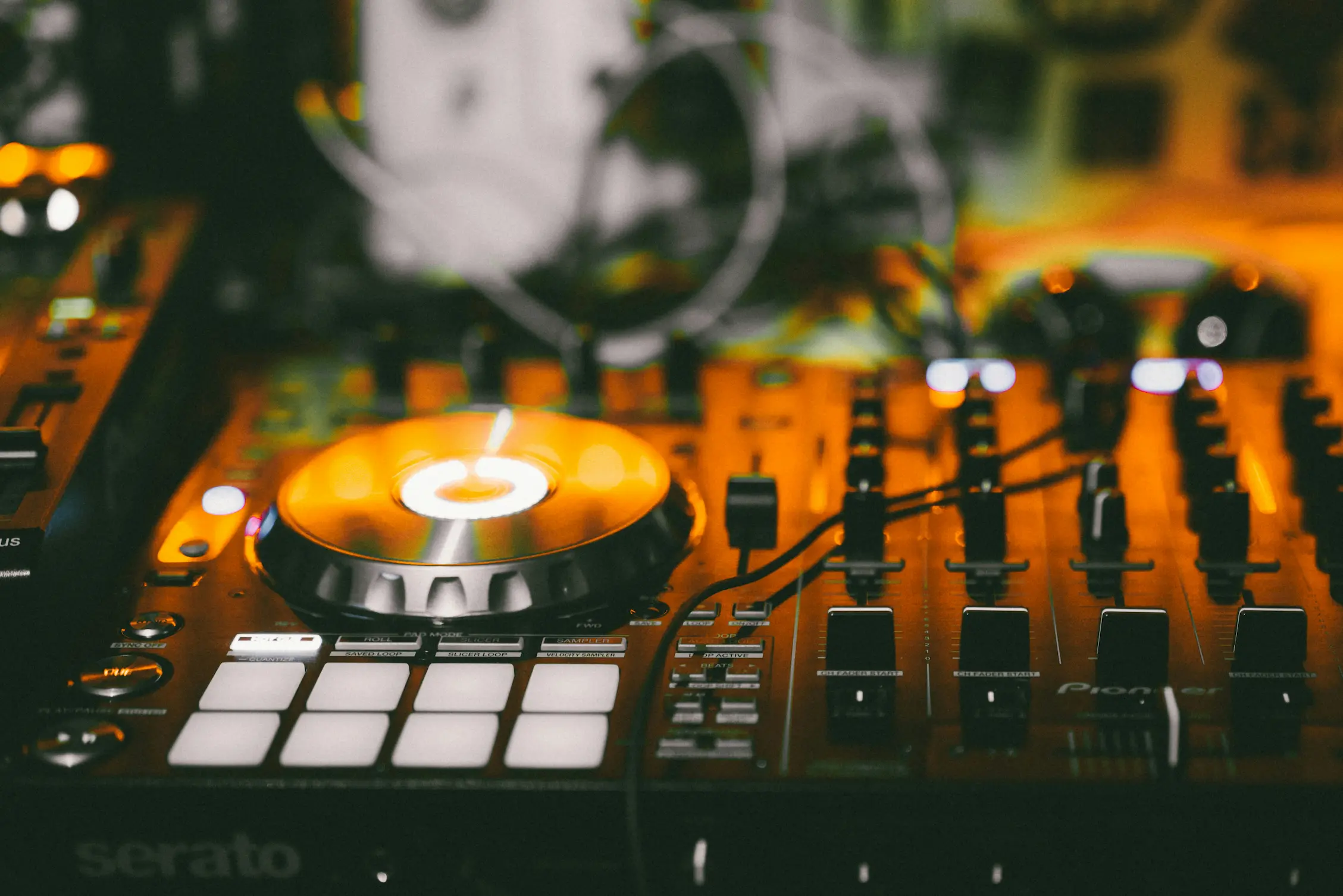 Platine de DJ Pioneer avec casque audio, ambiance lumineuse orangée