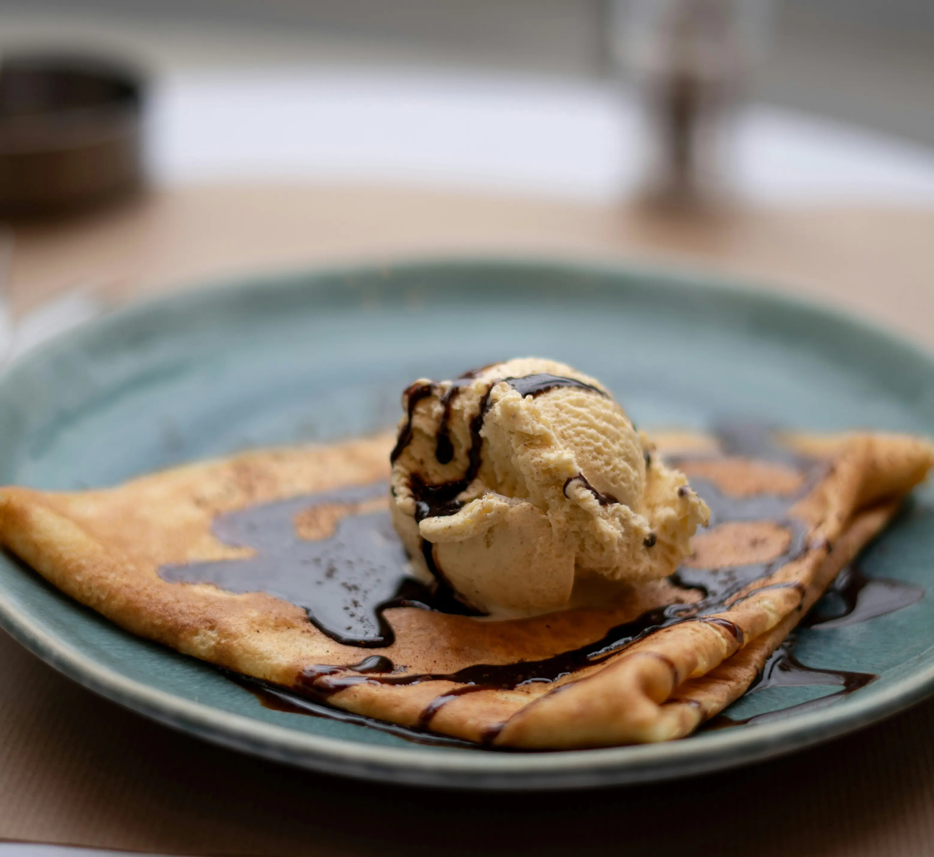 Crêpe garnie d'une boule de glace vanille et de sauce chocolat