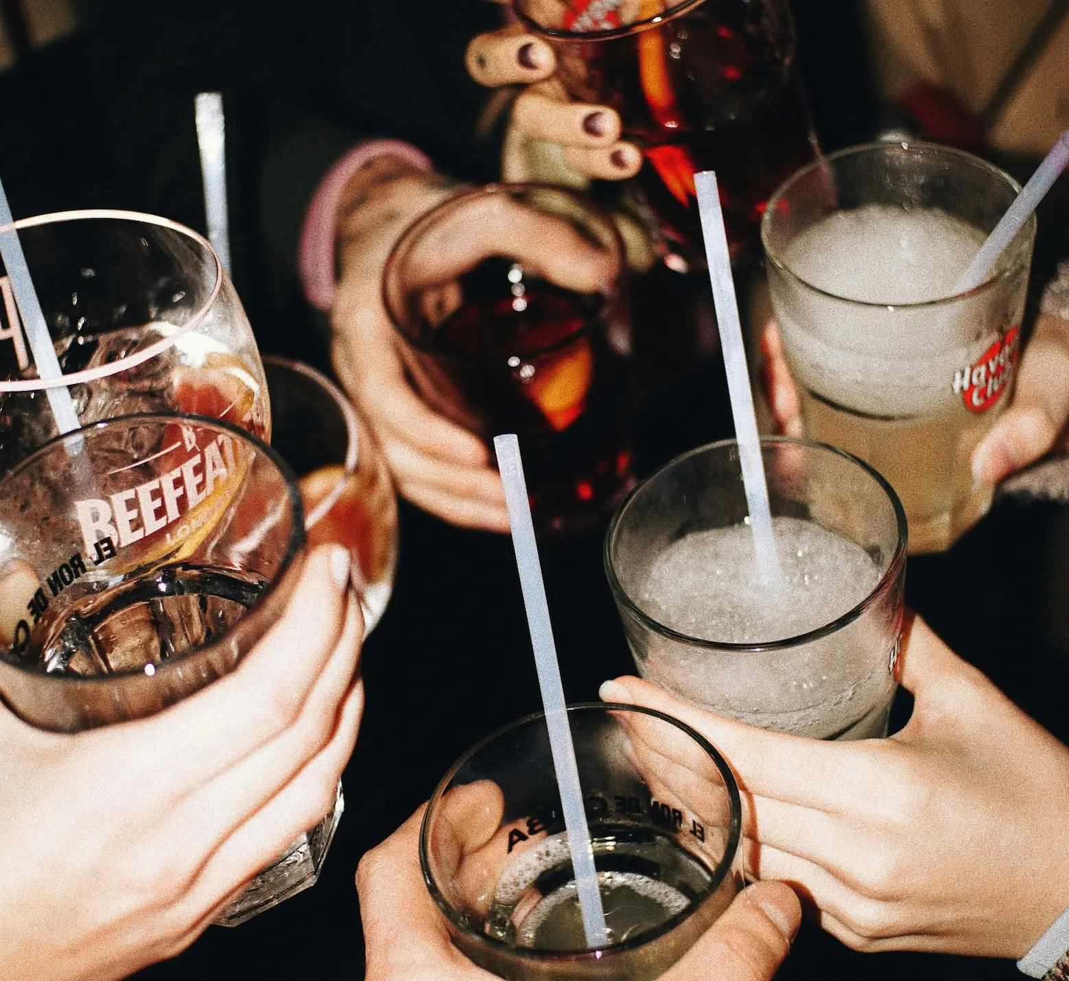 Groupe trinquant avec des cocktails et boissons lors d'une soirée